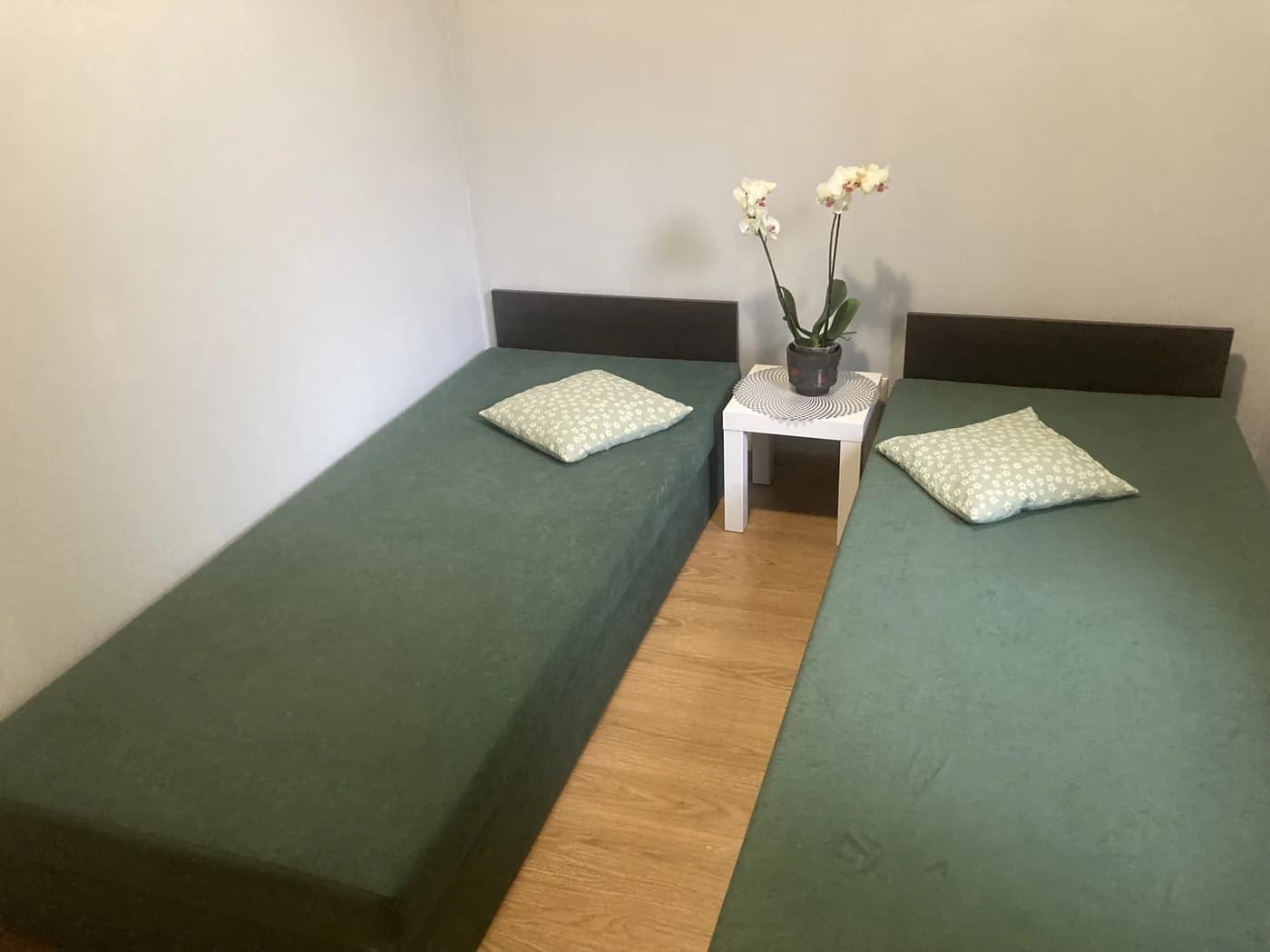 Dwa łóżka pojedyncze z orchideą